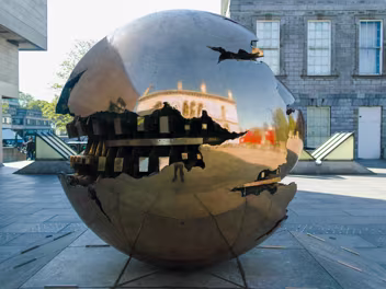 THE SFERA CON SFERA Dominating the forecourt of the iconic, brutalist Eavan Boland Library (formerly the Berkeley Library) stands Arnaldo...