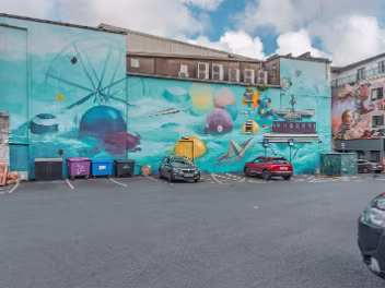 MURAL BY MAKER AND LAND The third and most recent layer of the wall's history began in 2021 when the 2017 mural was replaced by a new work by...