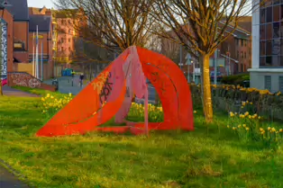 A RED METAL YOKE BY BOB SLOAN [THIS SCULPTURE IN BELFAST HAS NO NAME]-203533-1