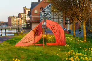 A RED METAL YOKE BY BOB SLOAN [THIS SCULPTURE IN BELFAST HAS NO NAME]-203534-1