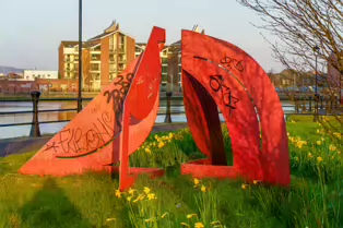 A RED METAL YOKE BY BOB SLOAN [THIS SCULPTURE IN BELFAST HAS NO NAME]-203535-1