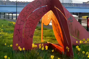 A RED METAL YOKE BY BOB SLOAN [THIS SCULPTURE IN BELFAST HAS NO NAME]-203536-1