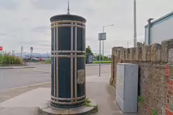 A FREESTANDING FINIAL-TOPPED CAST-IRON TRANSFORMER [DATING FROM 1900 AND LOCATED AT CONQUER HILL ROAD NEAR CLONTARF BUS GARAGE]-244415-1