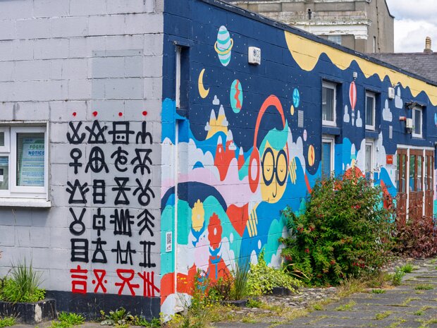 SYMBOLS ON SUSSEX STREET The distinctive symbolic artwork seen on several walls is the work of Signs of Power, the professional name for the...