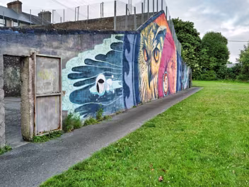 MICHAEL STREET MURAL JUNE 2025 The compelling mural on the Michael Street handball alley is primarily the creation of Kathrina Rupit, known as KinMx....
