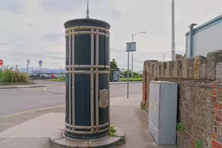 A FREESTANDING FINIAL-TOPPED CAST-IRON TRANSFORMER [DATING FROM 1900 AND LOCATED AT CONQUER HILL ROAD NEAR CLONTARF BUS GARAGE]-244415-1