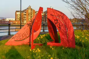 A RED METAL YOKE BY BOB SLOAN [THIS SCULPTURE IN BELFAST HAS NO NAME]-203535-1